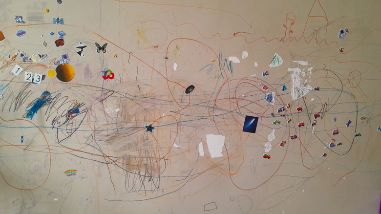 Bir evin boyalı duvarındaki çıkartmalar ve karalamalar.