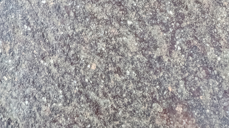 Doğal taş tezgahın üzerinde parlak altın kalp etiketi.