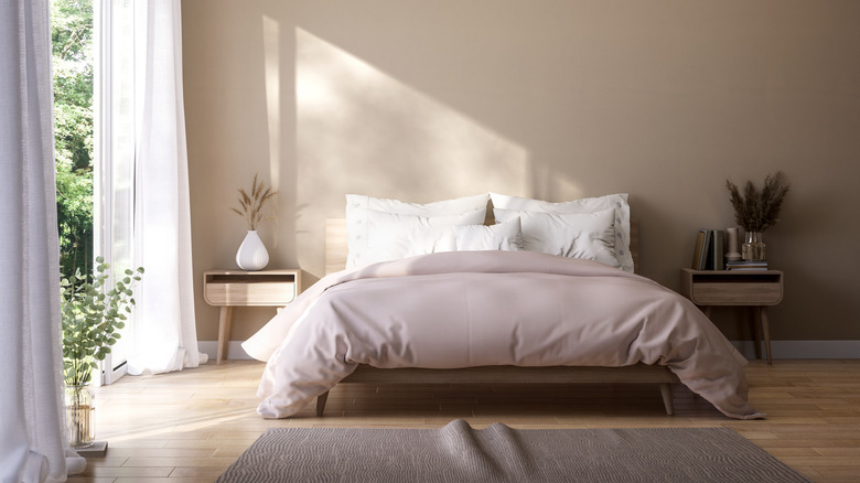 Nötr tonlar, kral boy yatak, iki komodin ve büyük açık pencere ile modern, aydınlık yatak odası