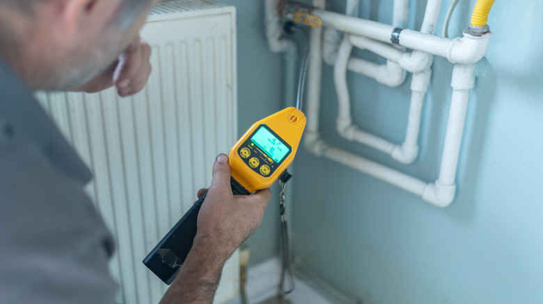 Gaz dedektörü kullanan teknisyen