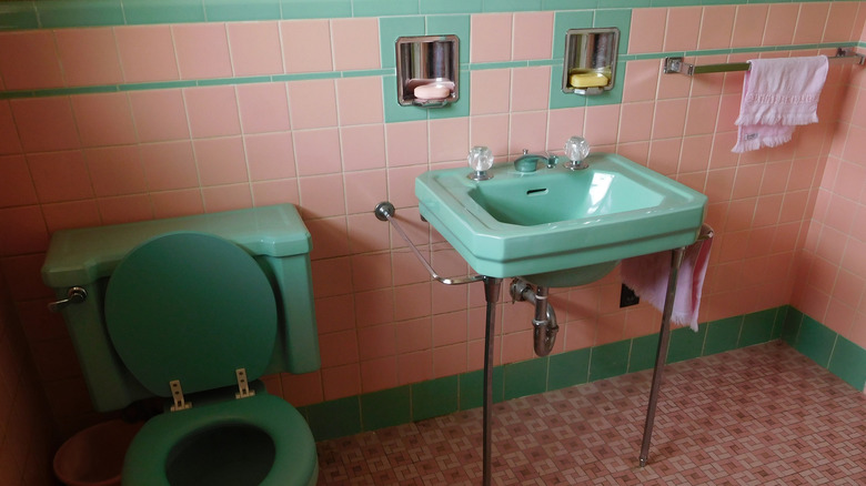Renkli lavabo, tuvalet ve pembe fayanslarla 1950'lerden kalma banyo