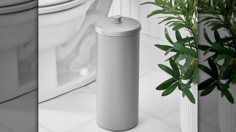 tuvalet ve yeşillik yanında metal gizli tuvalet kağıdı tutucusu