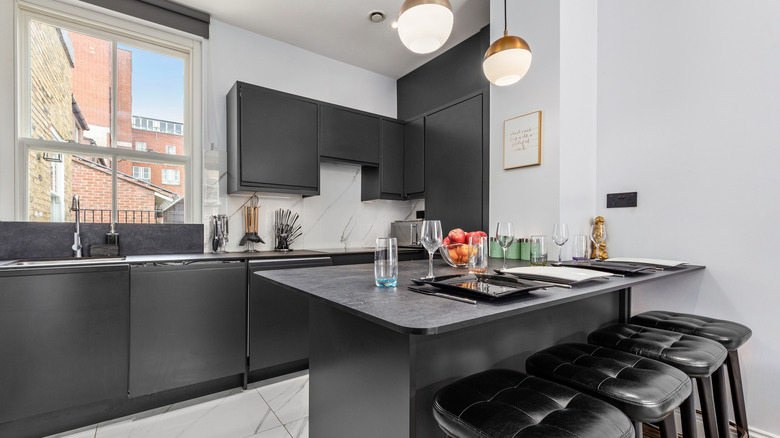 Büyük bir backsplash ve ince tezgahı olan modern bir mutfak