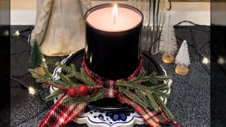 Cam mumluk ve cam tabaktan yapılmış kardan adam şapkalı mumun görünümü