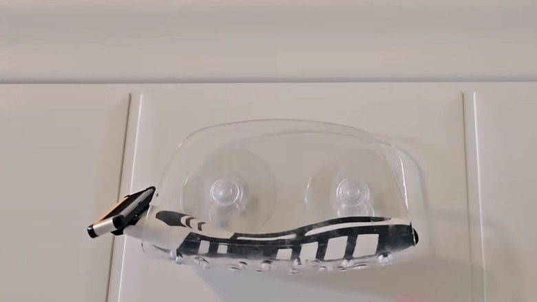 Yeni tıraş makinesiyle duş duvarındaki vantuzlu sünger tutucu