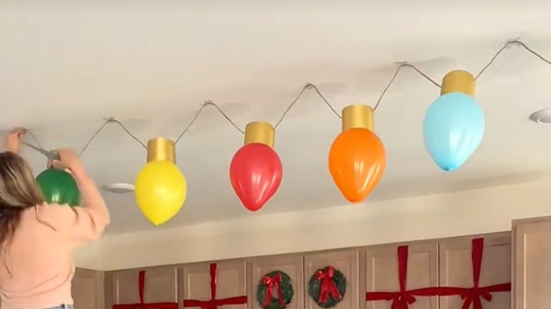 Tavana büyük boy Noel ışık süsleri asan kadın