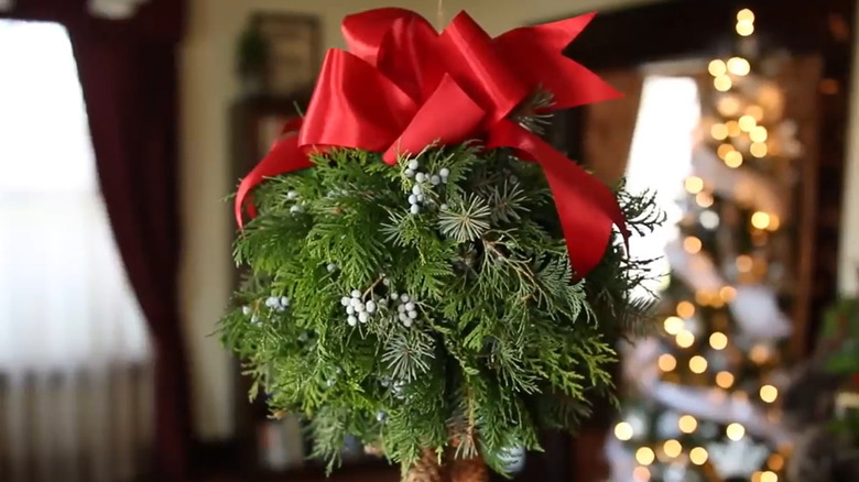 Noel ağacının yanında asılı öpüşme topu