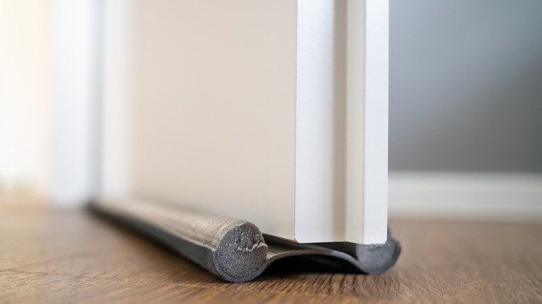 Altta bir hava akımı engelleyici bulunan bir kapı, hava akımını önlemek için tasarlanmıştır.