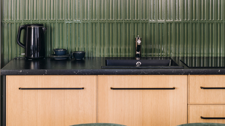 Ahşap dolaplı ve siyah tezgahlı bir mutfak