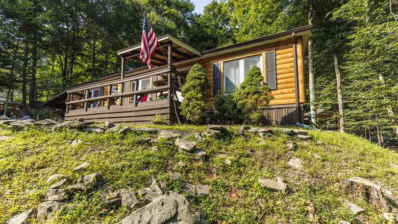 Prefabrik bir ahşap kulübe, ormanın derinliklerindeki kayalık arazide yer alıyor