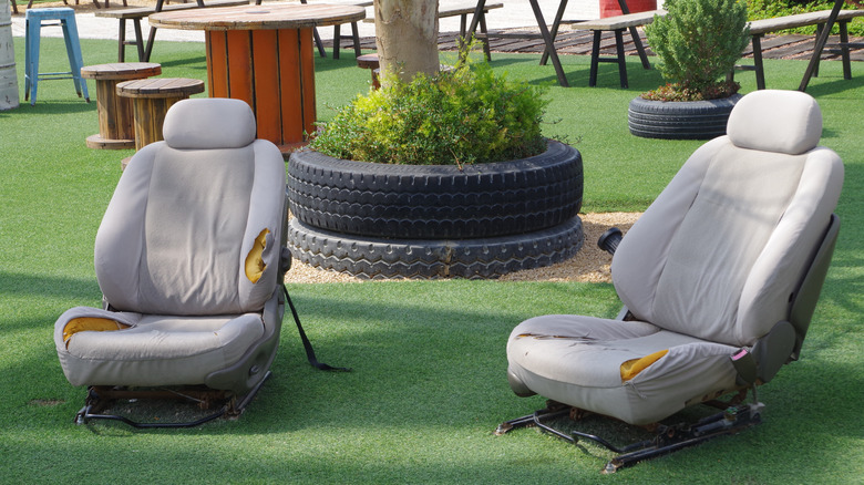 Bahçede iki eski araba sandalyesi.