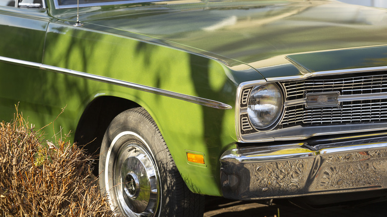 Eski yeşil bir arabanın ön kısmı.