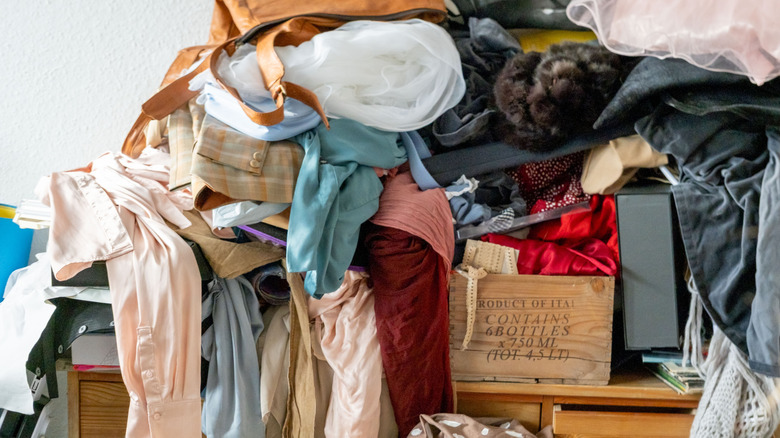 Giysiler ve diğer eşyalarla kaplı masa