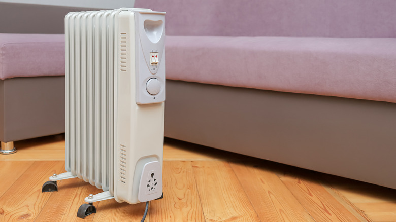 Kanepenin yanında yerde duran bir yağ ısıtıcısı