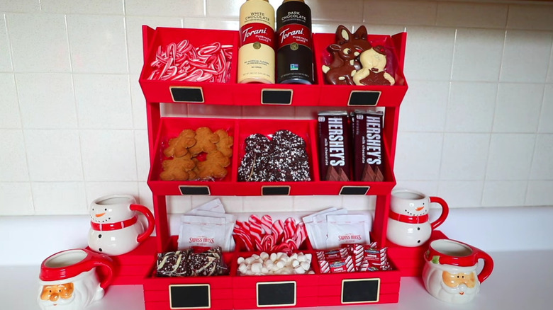 İçinde malzemeler ve yanlarında kupalar bulunan bir DIY sıcak çikolata barı.