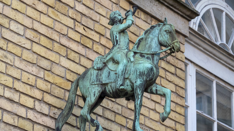 dışarıda mavi patinalı at üstünde metal adam heykeli