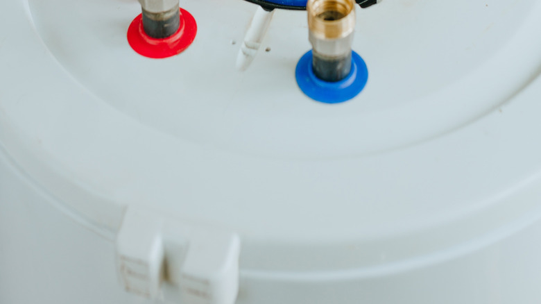 Su ısıtıcısında kablolama üzerinde çalışan kişi