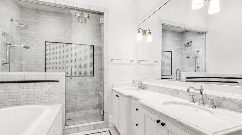 Beyaz zeminli, duvarlı, küvetli, duşlu, lavabolu ve dolaplı dar banyo