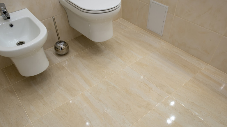 Işığı yansıtan parlak kaplamalı bej fayanslı banyo