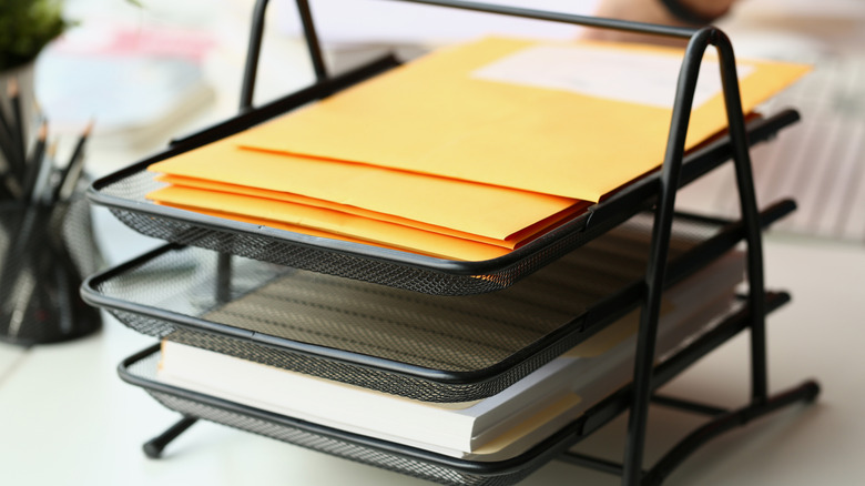 Katmanlı metal masa düzenleyici rafındaki kağıtlar