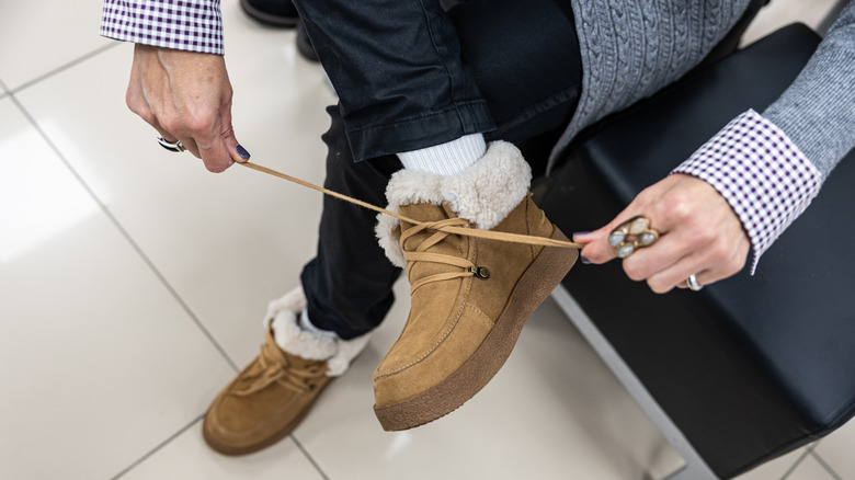 süet kışlık botlarını bağlayan kişi