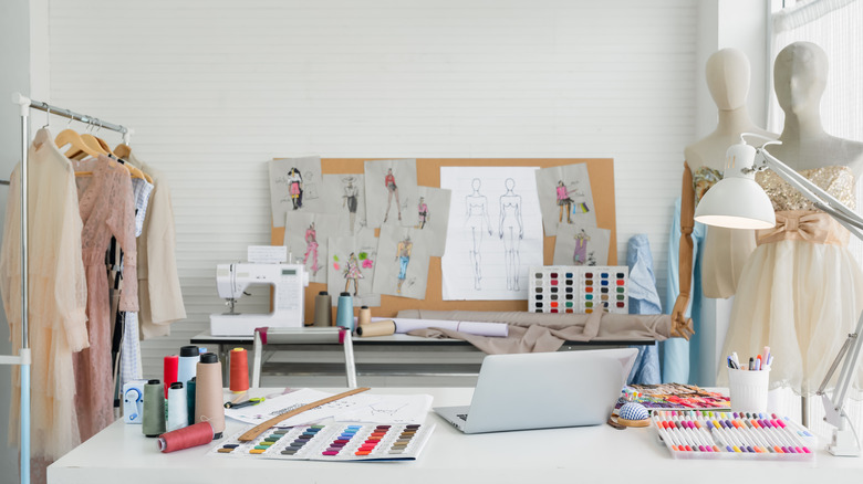 Giysiler, tasarımlar, mankenler ve dikiş aletleriyle dolu bir oda