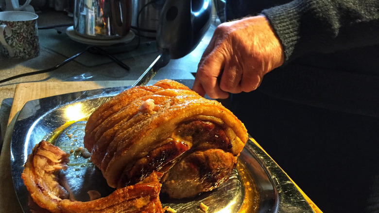 kızartmayı kesmek için elektrikli bıçak kullanan eller