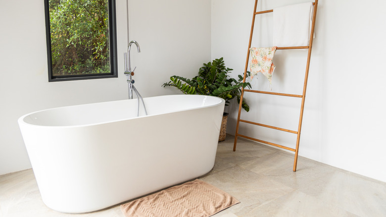 Bağımsız küvetli ve taş zeminli nötr aydınlık banyo