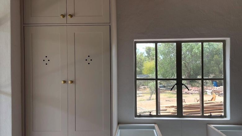 Uzun bir dolapta dolap havalandırma delikleri bulunan, yakın zamanda yenilenmiş bir mutfak