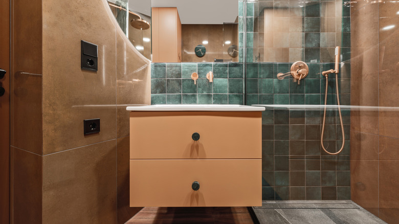 Mavi zellige çini backsplash ve terakota duvarları ve zeminleri olan bir banyo.