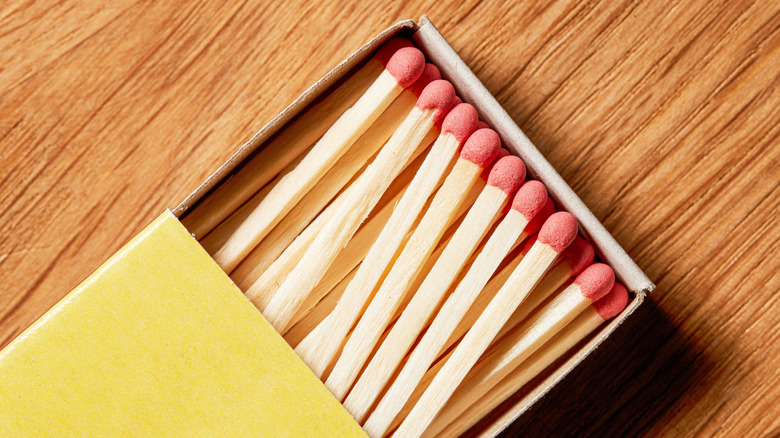 Ahşap masanın üzerindeki kibrit kutusundaki kibritler.