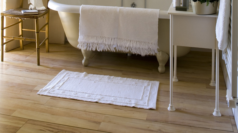 Arka planda basit oda bölücüsü olan şık beyaz banyo