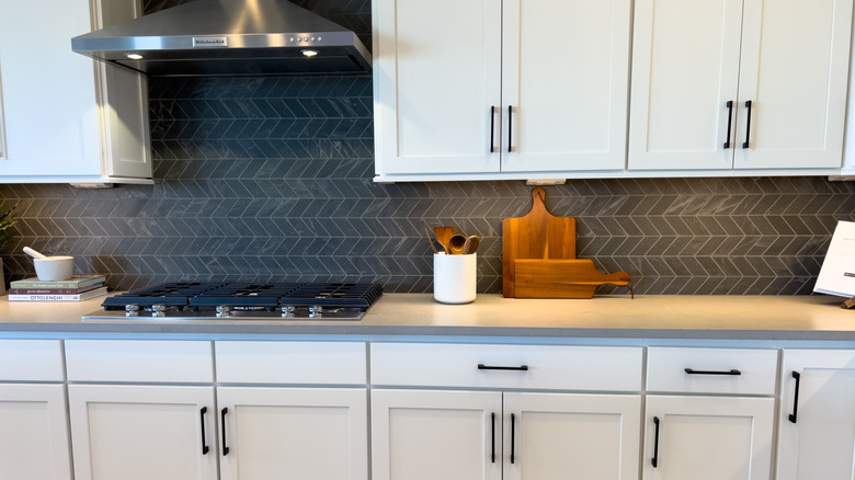 Koyu gri fayanslı beyaz bir mutfak