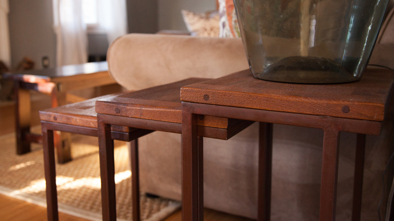 Oturma odasında ahşap iç içe geçme masalar.