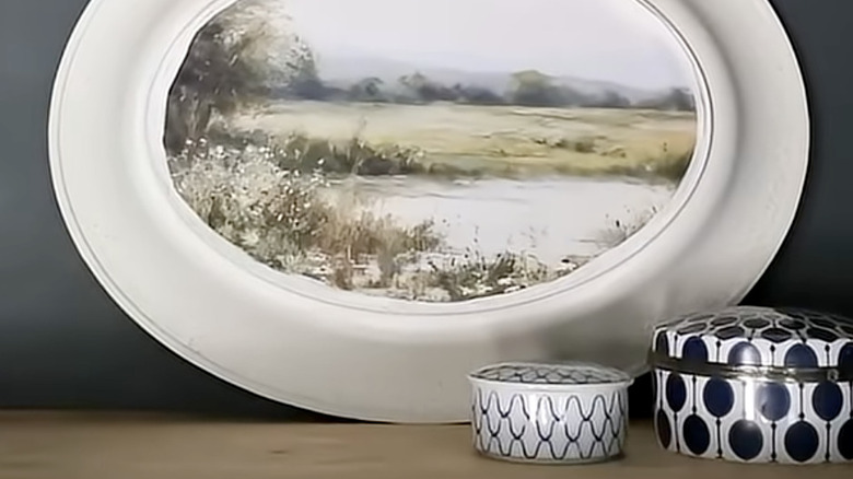 Oturma odasındaki bir duvara yaslanmış, ortasına sanat eseri yapıştırılmış bir Dolar Ağacı tepsisi.