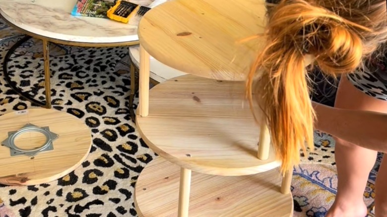 Ahşap tahtalardan ve dübel çubuklarından DIY dönen ayakkabı rafı yapan kişi