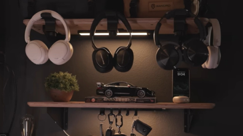 Kulaklıkların, model arabanın ve cep telefonunun sergilendiği duvar rafları