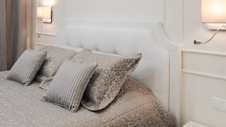 Beyaz püsküllü döşemeli başlıklı yatak