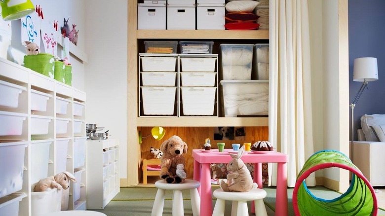 Oyun odası perdesinin arkasına gizlenmiş oyuncak kutuları