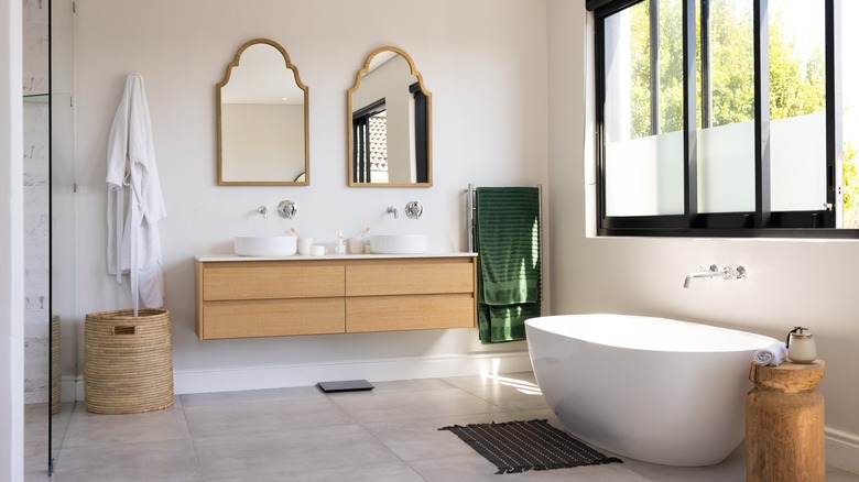 Çift ahşap tuvalet masası ve bağımsız küvet içeren klasik banyo.