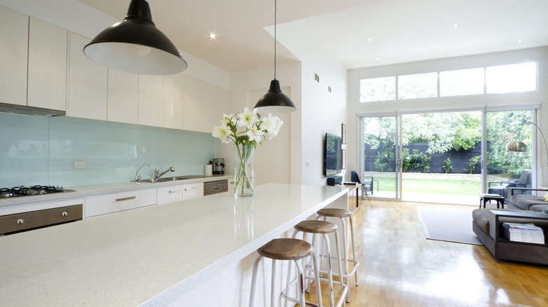 Beyaz tezgahlı ve pastel mavi backsplash'li açık konsept mutfak