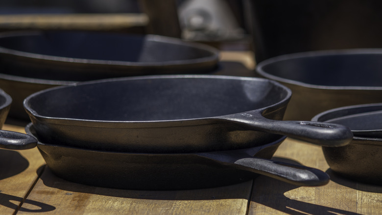 Ahşap bir rafta dökme demir tavalar