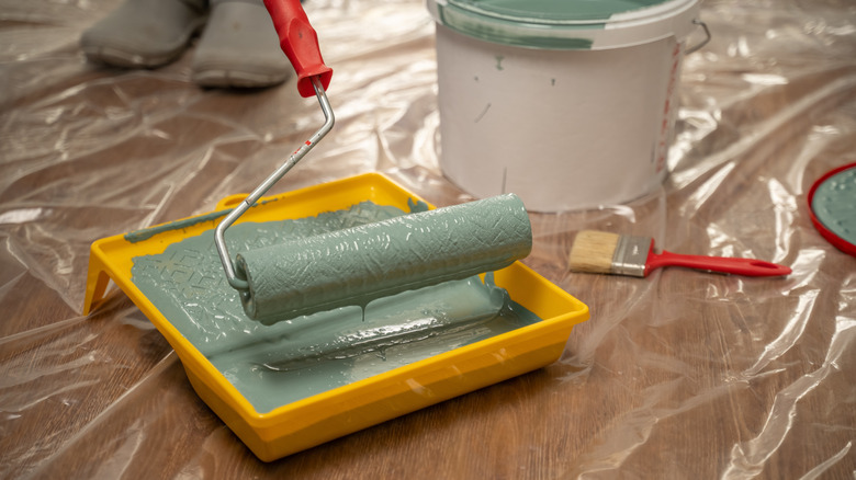 köpük ruloyu boya tepsisine batıran kişi