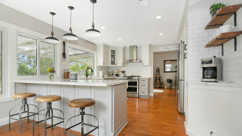 Kahve köşesi ve yemek barı bulunan modern bir çiftlik evi mutfağı