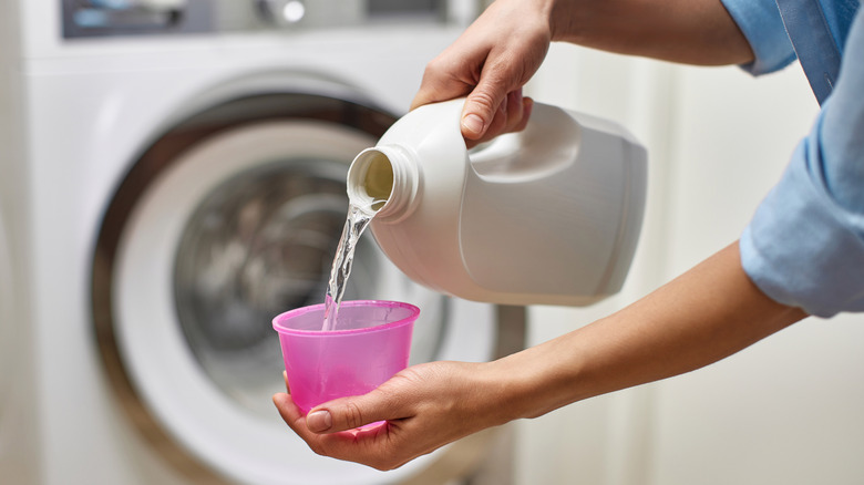 sıvı çamaşır deterjanı döken kişi