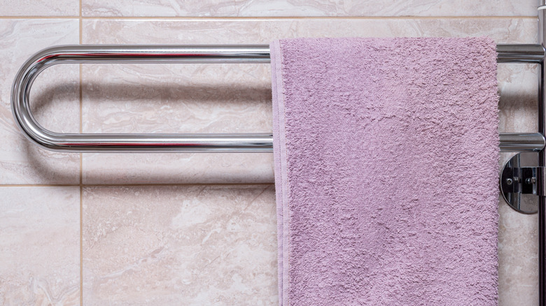 Krom ısıtmalı havlu askısına bir havlu asılıyor