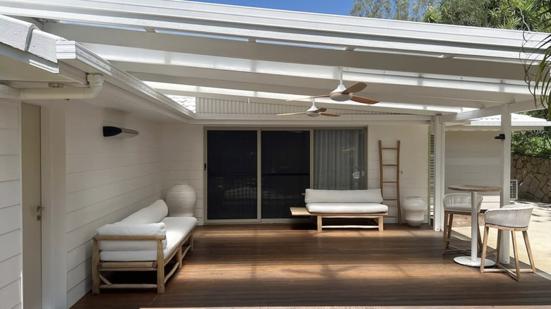 Tuğla duvarın üzerine beyaz kaplamalı bir ev