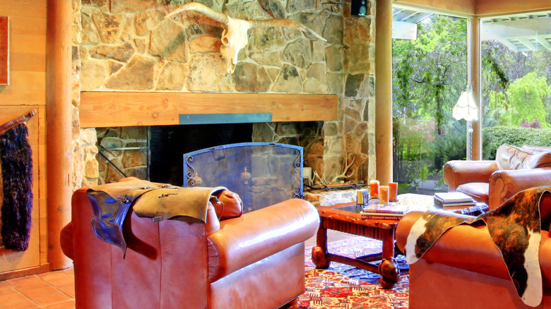 Çiftlik oturma odası, deri mobilyalar ve duvarda uzun boynuzlu kafatası