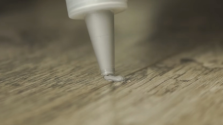 Yonmuş bir LVP zeminine macun uygulanması.