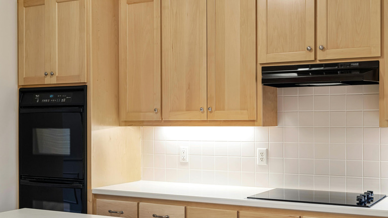 Üstte aksesuarları olan ahşap mutfak dolapları